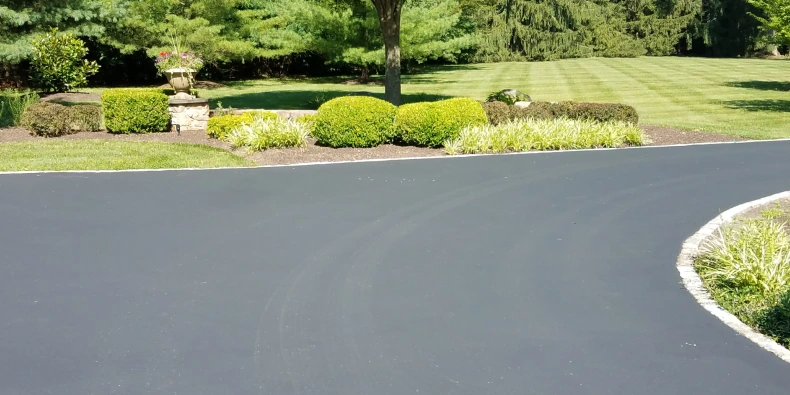 Asphalt driveway sealcoating showing fresh surface finish with cost measured per square foot for budgeting purposes