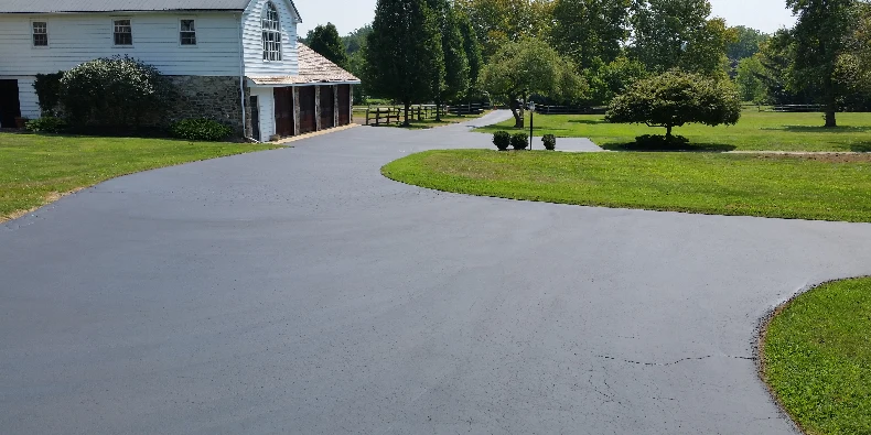 Freshly sealcoated asphalt driveway curing before vehicles are driven on the surface